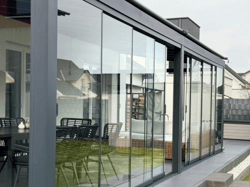 Ganzglasschiebeanlage als seitlicher Abschluss einer Terrassenüberdachung